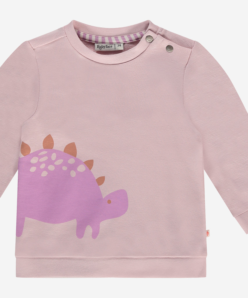Details:  This fashionable baby sweatshirt is made with a cute dino print, a round neckline, ribbed arm cuffs and waistband, and push buttons on the side for easy opening. Perfect for any little one, this sweatshirt provides both comfort and style.  Color: Blush  Composition:  95% BCI cotton/5% elasthan  