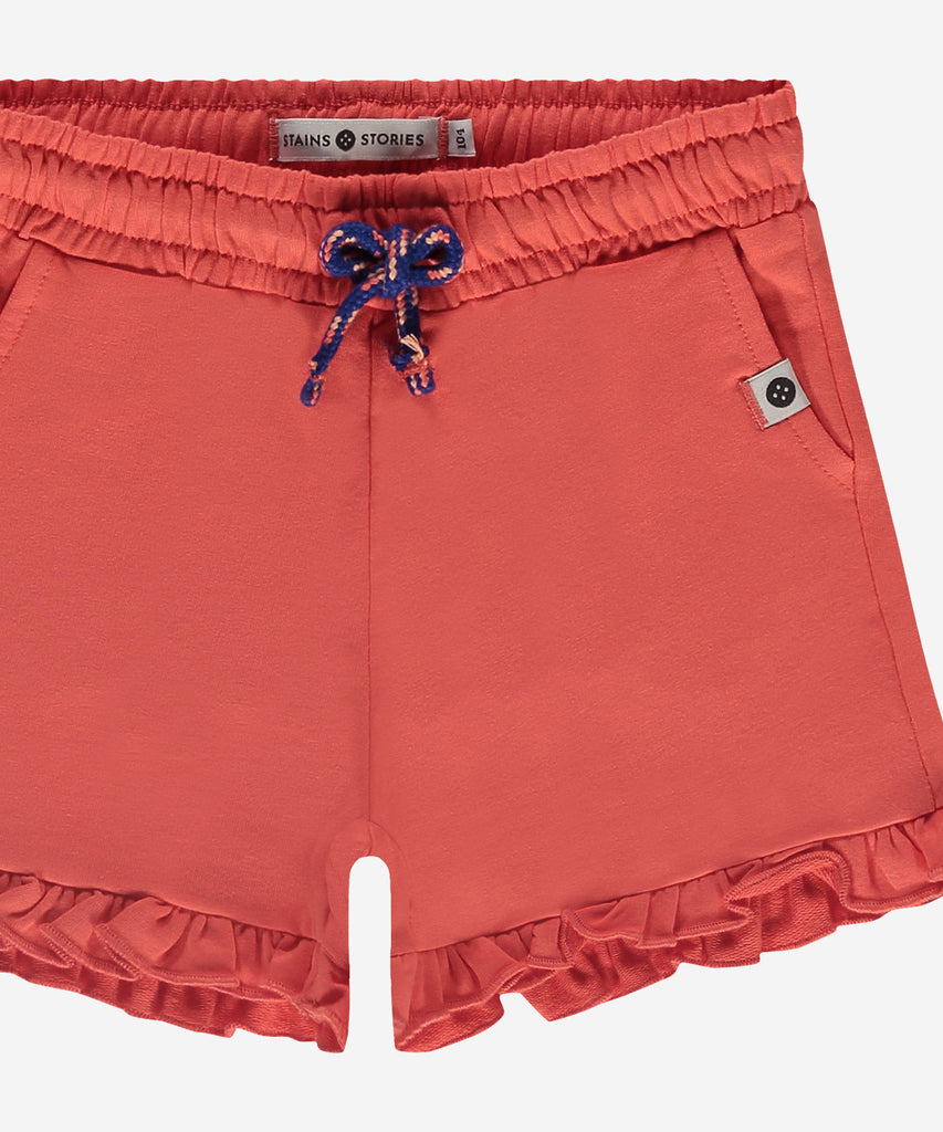 Details: Expertly crafted with a comfortable elastic waistband, these Soft Shorts Ruffles Grapefruit provide a stylish and comfortable fit. The delicate ruffles add a feminine touch to these soft shorts, making them perfect for lounging or wearing out and about.  Complete with practical pockets, these shorts are a must-have for any wardrobe.  Color: Grapefruit  Composition: 95% BCI cotton/ 5% elasthane  