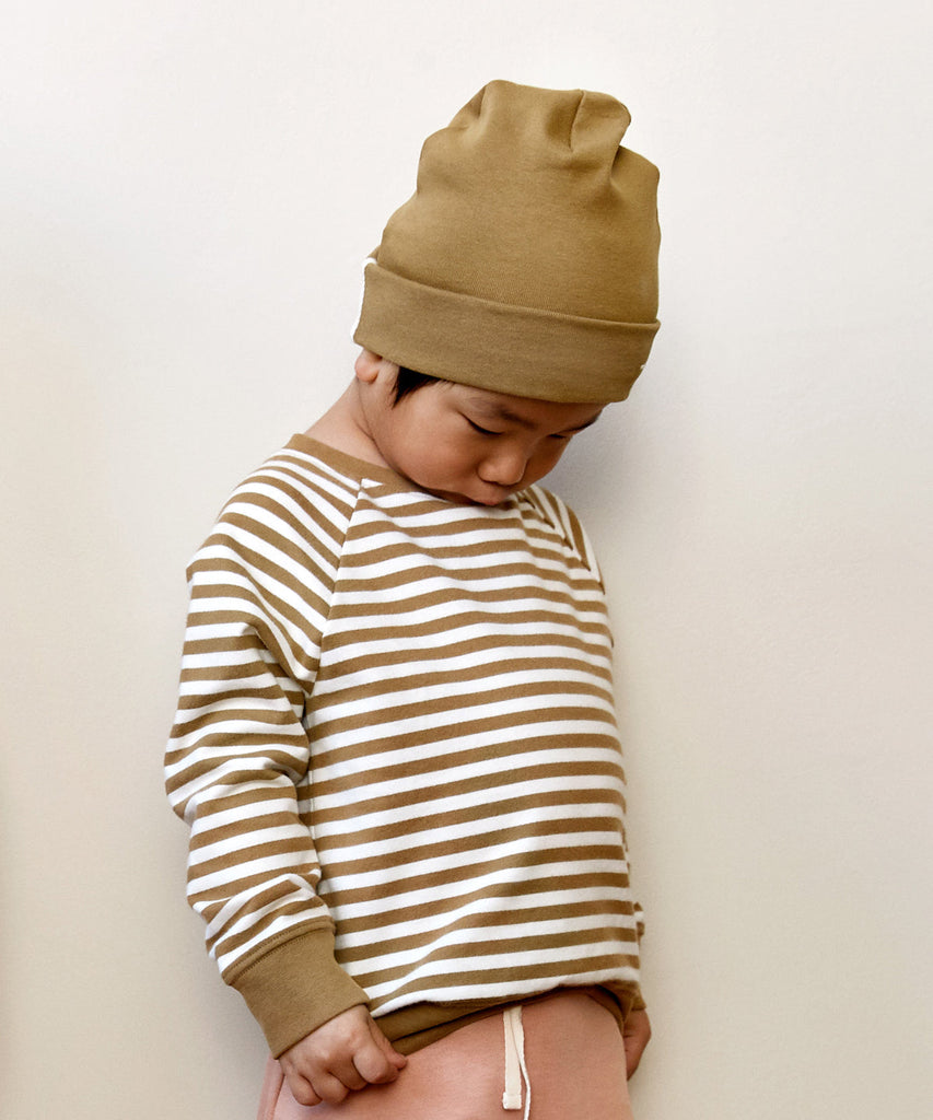 Details: Fitting comfortably over the head, this beanie offers lightweight protection from the cold. Made from the softest organic cotton rib, it has a folded brim and a herringbone detail on the sides.  Color: nearly black  Composition: 96% Organic Cotton Jersey, 4% Elastane Rib  Made in Portugal
