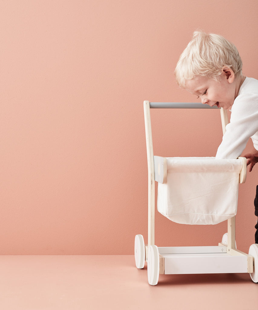 Kid's Concept  A wooden shopping trolley with 100% cotton storage. A great role play toy that encourages mobility and is the perfect addition to any child’s play shop. Use both the upper basket and lower tray to collect groceries as you wander the isles!  Age: 2y+  Size: 36 x 28.5 x 50cm