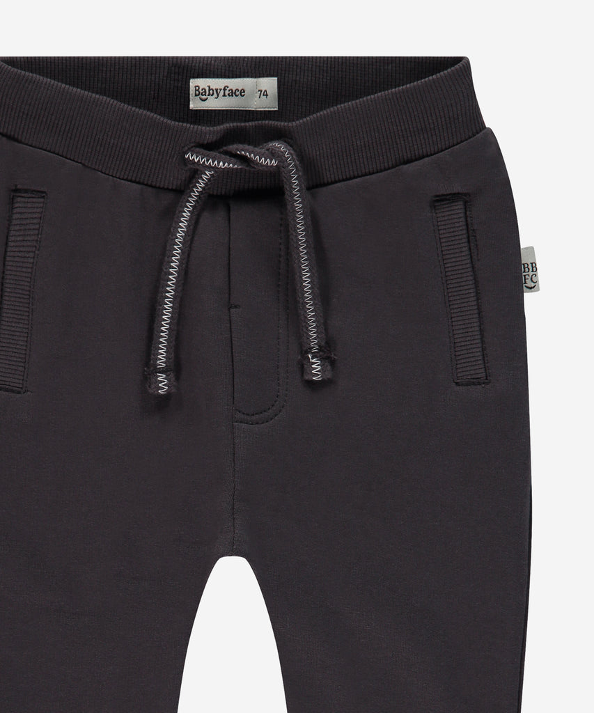 Details:  Introducing the soft Jogg Pants, designed for your little one's comfort. Crafted from a soft and durable fabric, these pants feature an elastic waistband for a secure and comfortable fit.  Ensure your child's adventures are as comfortable as can be with these Jogging Pants.  Color: Dark grey  Composition: 95% BCI cotton/5% elasthan  