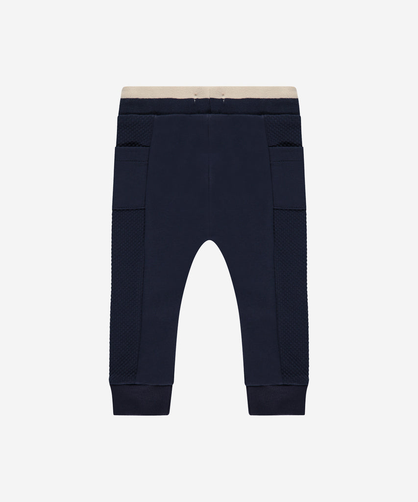 Details:  Introducing the soft Jogg Pants, designed for your little one's comfort. Crafted from a soft and durable fabric, these pants feature an elastic waistband for a secure and comfortable fit.  Ensure your child's adventures are as comfortable as can be with these Jogging Pants.  Color: Indigo  Composition: 95% BCI cotton/5% elasthan  