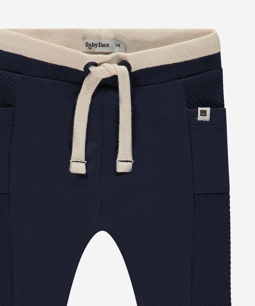 Details:  Introducing the soft Jogg Pants, designed for your little one's comfort. Crafted from a soft and durable fabric, these pants feature an elastic waistband for a secure and comfortable fit.  Ensure your child's adventures are as comfortable as can be with these Jogging Pants.  Color: Indigo  Composition: 95% BCI cotton/5% elasthan  