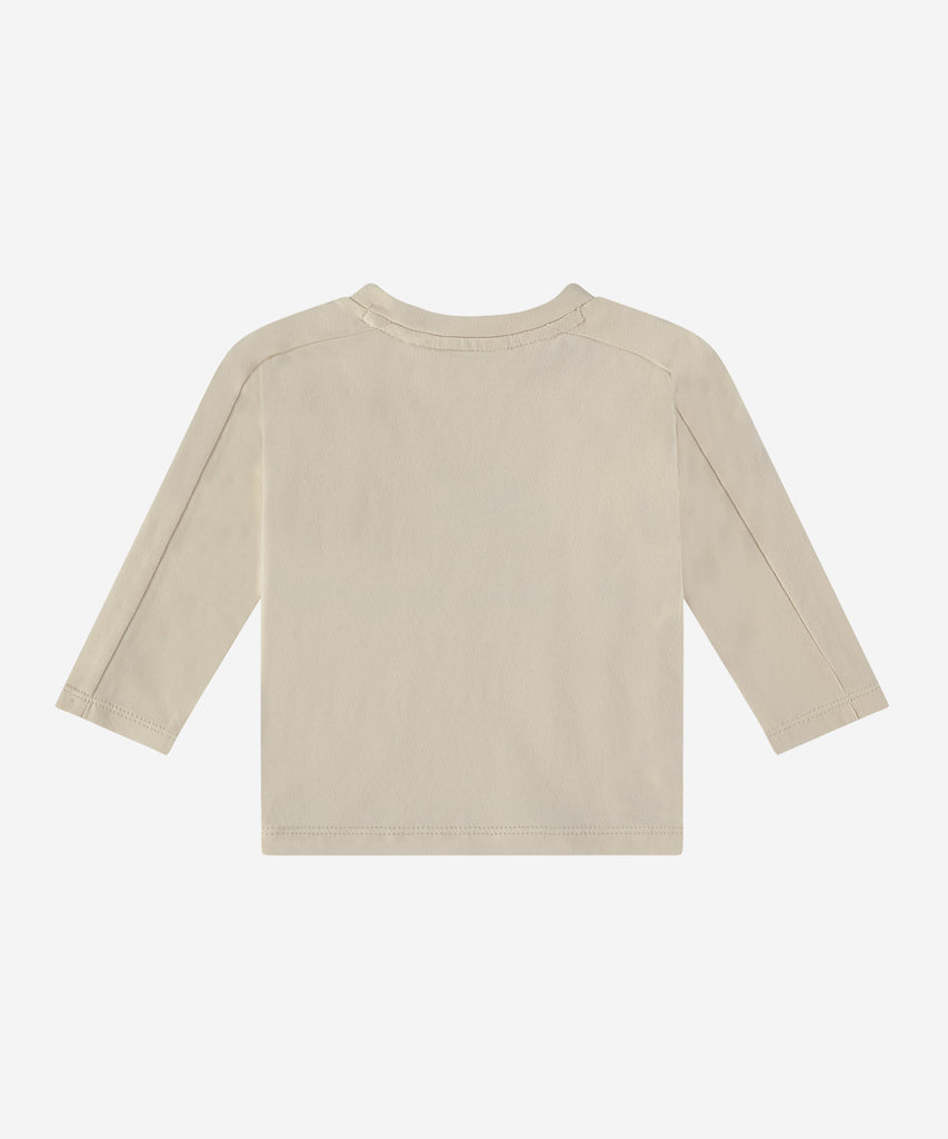 Details:  This baby long sleeve t-shirt features a round neckline and an easy opening with 2 push buttons for added convenience. With its soft cream color and cute animal band design, it's perfect for spreading good vibes!  Color: Cream  Composition:   95% BCI cotton/5% elasthan  