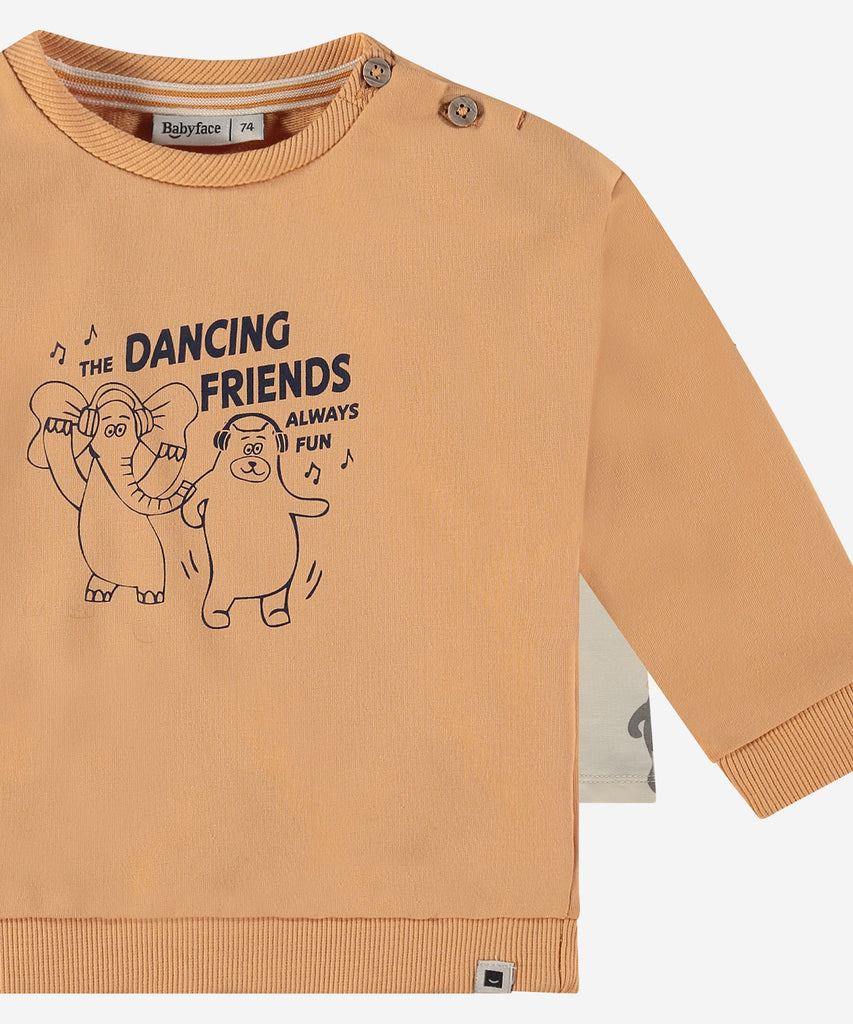 Details:  This fashionable baby sweatshirt is made with a print of dancing friends, a round neckline, ribbed arm cuffs and waistband, and push buttons on the side for easy opening. Perfect for any little one, this sweatshirt provides both comfort and style.  Color: Pale orange  Composition:  95% BCI cotton/5% elasthan  