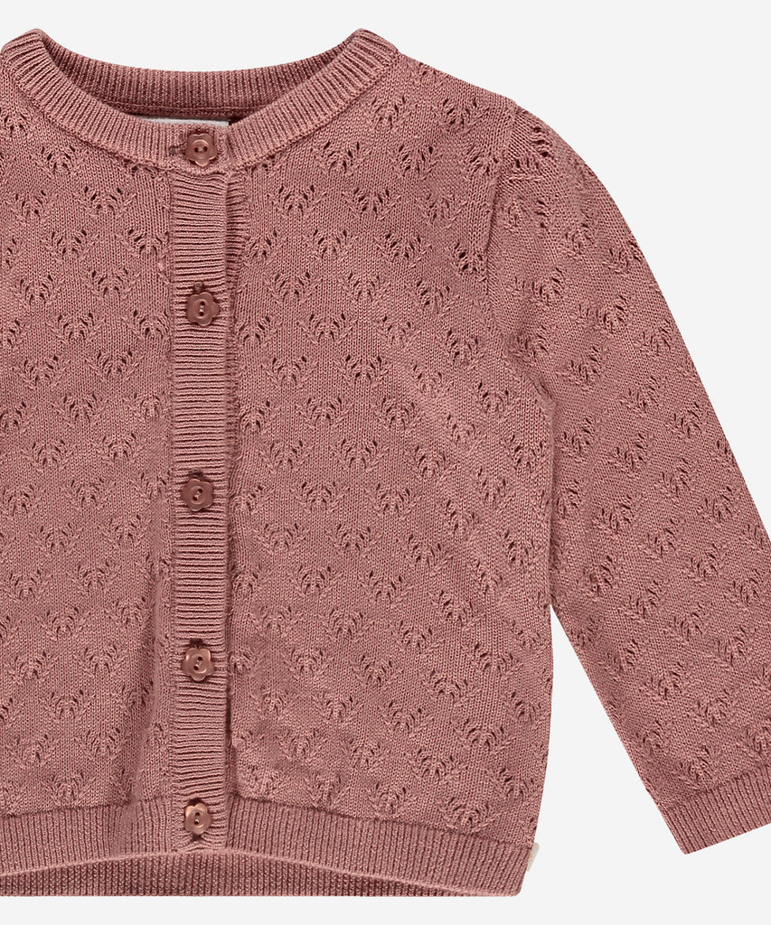 Details:  This baby knit pointelle cardigan in a soft blossom hue will keep your little one cozy and stylish. Crafted with a round neckline and convenient button closure, this cardigan is perfect for layering over any outfit. A must-have addition to any baby's wardrobe.  Color: Blossom  Composition: Summer 202