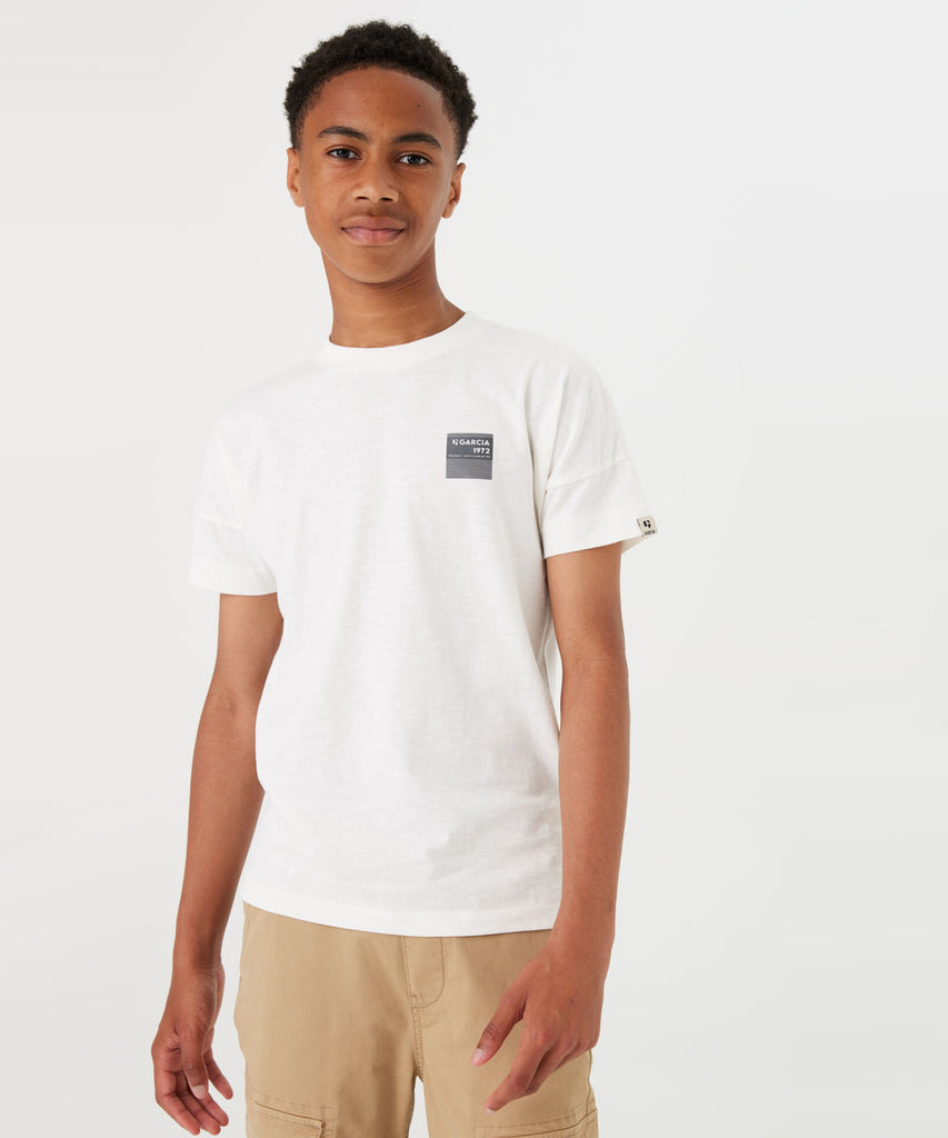 Details:  This short sleeve drop shoulder t-shirt in off white features a round neckline and a unique "Another Day" photo print on the back. Perfect for both casual and statement looks, this t-shirt adds an artistic touch to any outfit.  Color:  Off white  Composition: 100% Cotton 