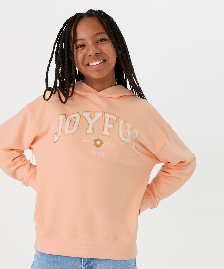 Details: ﻿ This hooded sweater in peach features a joyful print on the front, creating a playful yet stylish look. The ribbed arm cuffs and waistband provide a comfortable fit. Perfect for adding a touch of happiness to your daily wardrobe.  Color: Peach bloom  Composition:  80% Cotton, 20% Polyester   