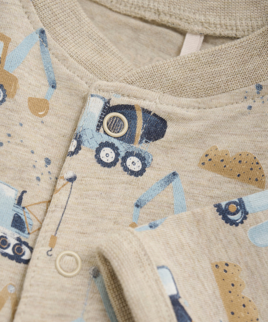 Details: This Beige Melee Baby Suit features a fun all over print of trucks, perfect for any little one who loves vehicles. With long sleeves and a round neckline, this jumpsuit will keep your baby warm and comfy. The push buttons make dressing and changing easy.  Color: Beige melee  Composition: Single Jersey 90% Cotton/ 5% Polyester/ 5% Elastane 