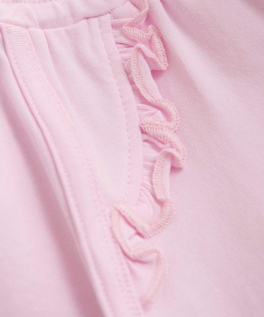 Details: These baby sweat shorts are both stylish and functional. Designed in a trendy pink color, they feature convenient pockets and an elastic waistband for easy wear. Perfect for active little ones on the go.  Color: Pink Tulle  Composition:  Organic Single Jersey 95% Cotton/ 5% Elastane  
