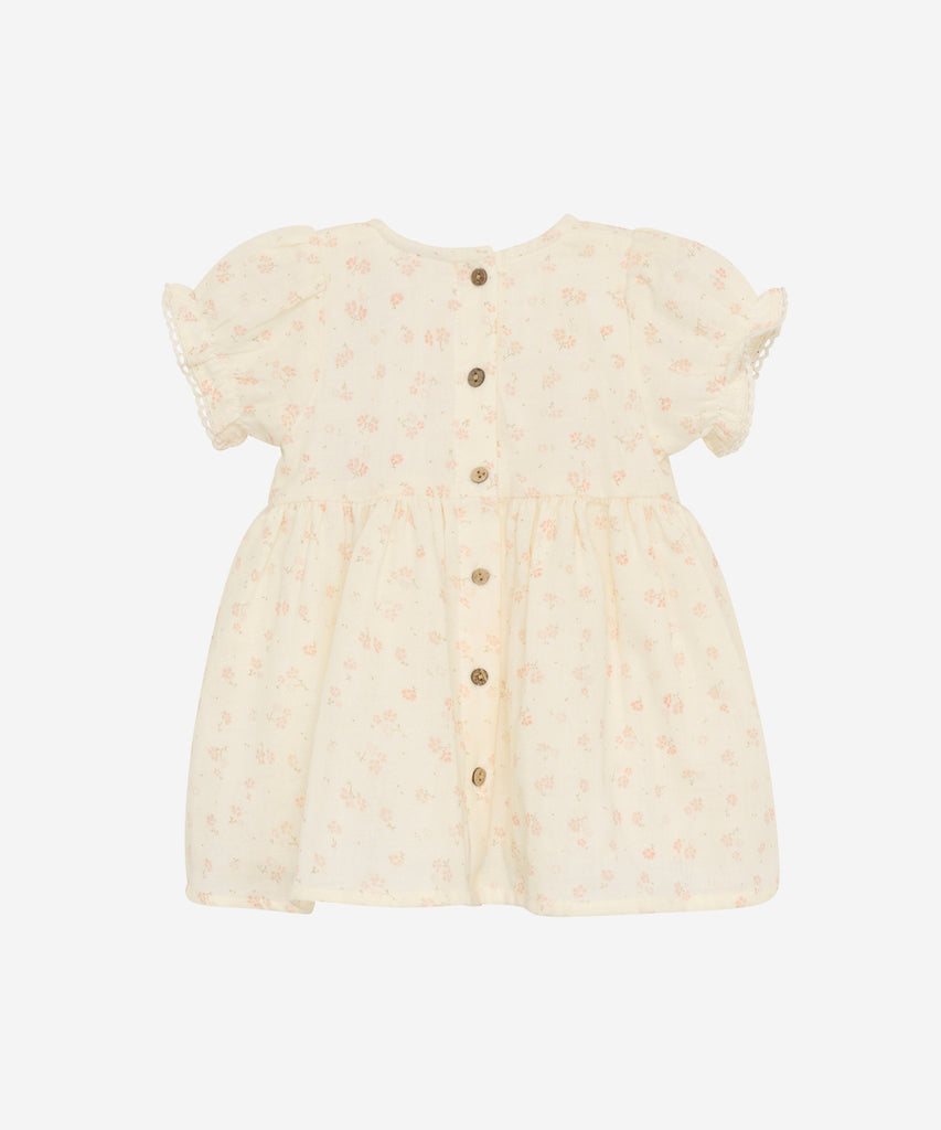 Details: Expertly crafted for your little one, this Woven Baby Dress features a beautiful all-over flower print and a round neckline. The back buttons make dressing a breeze, while the high-quality woven fabric ensures comfort and durability. Perfect for everyday wear or special occasions, this dress is a must-have for any stylish baby's wardrobe.  Color: Eggnog  Composition:  100% Cotton  