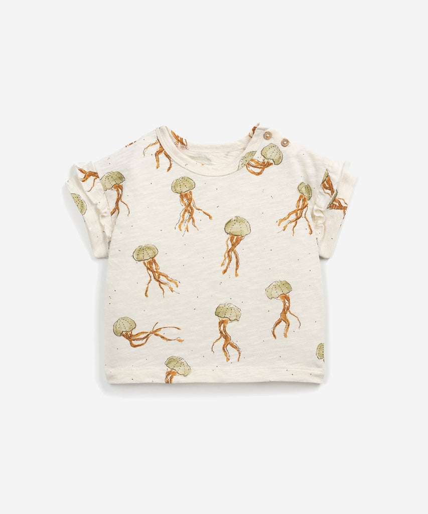 Details:  This T-shirt is made of jersey stitch organic cotton, Fiber colour. It has a round neck, frilly details on the sleeves, an opening on the shoulder with coconut buttons and our jellyfish print.  Colour: Fiber  Composition:  100.0% Organic Cotto