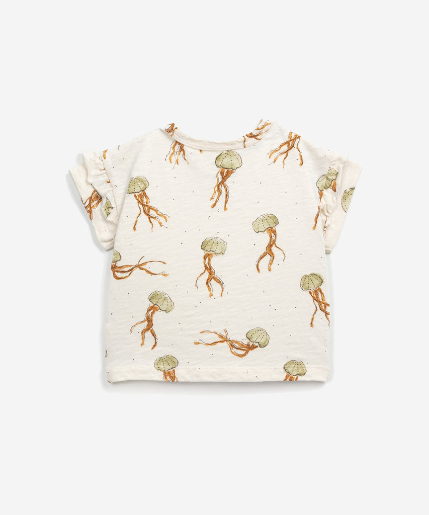 Details:  This T-shirt is made of jersey stitch organic cotton, Fiber colour. It has a round neck, frilly details on the sleeves, an opening on the shoulder with coconut buttons and our jellyfish print.  Colour: Fiber  Composition:  100.0% Organic Cotto