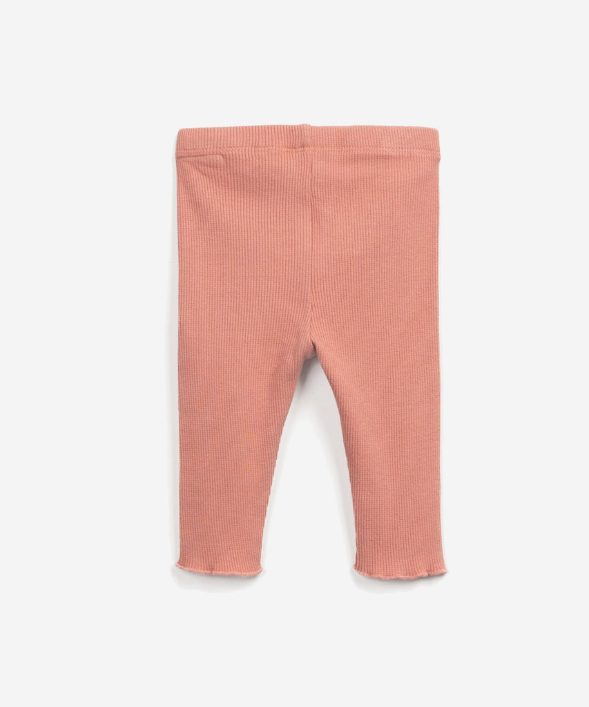 Details: These leggings are made of jersey stitch organic cotton, Coral colour. The model has ribbing, an elastic waist and a decorative coconut button.  Colour: Coral  Composition:  98.0% Organic Cotton,2.0% Elastane  