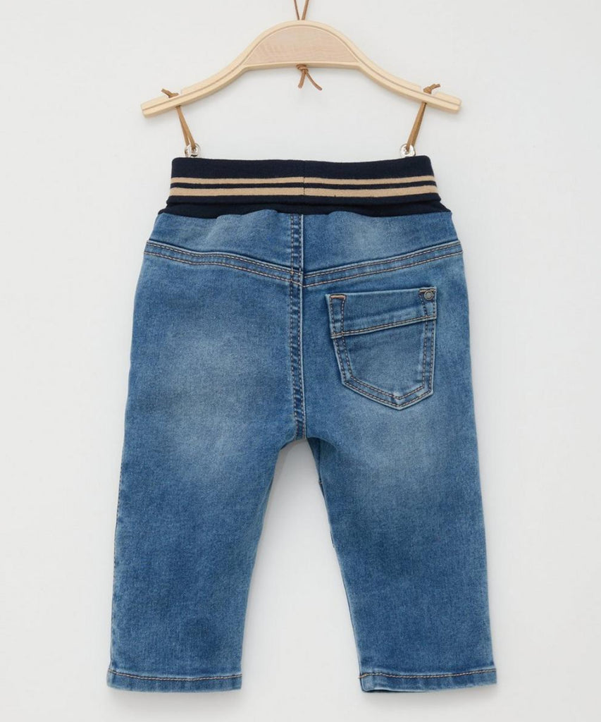 Details:  These Soft Baby Pull Up Jeans in Blue Denim offer both comfort and style for your little one. The soft fabric and elastic waistband ensure a comfortable fit, while the pockets add functionality. Perfect for everyday wear, these jeans are a must-have for any baby's wardrobe.  Color: Blue denim  Composition:  074%CO 024%PES 002%EL  