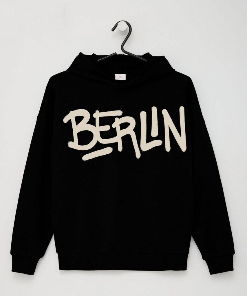 Details: Upgrade your Teen's wardrobe with our boys' Hoodie Berlin Black. Made from high-quality materials, it features a sleek black design with a Berlin print on the front. Its ribbed arm cuffs and waistband provide a snug fit and added comfort. Perfect for any casual occasion.  Color: Black   Composition:  090%CO 010%PES  