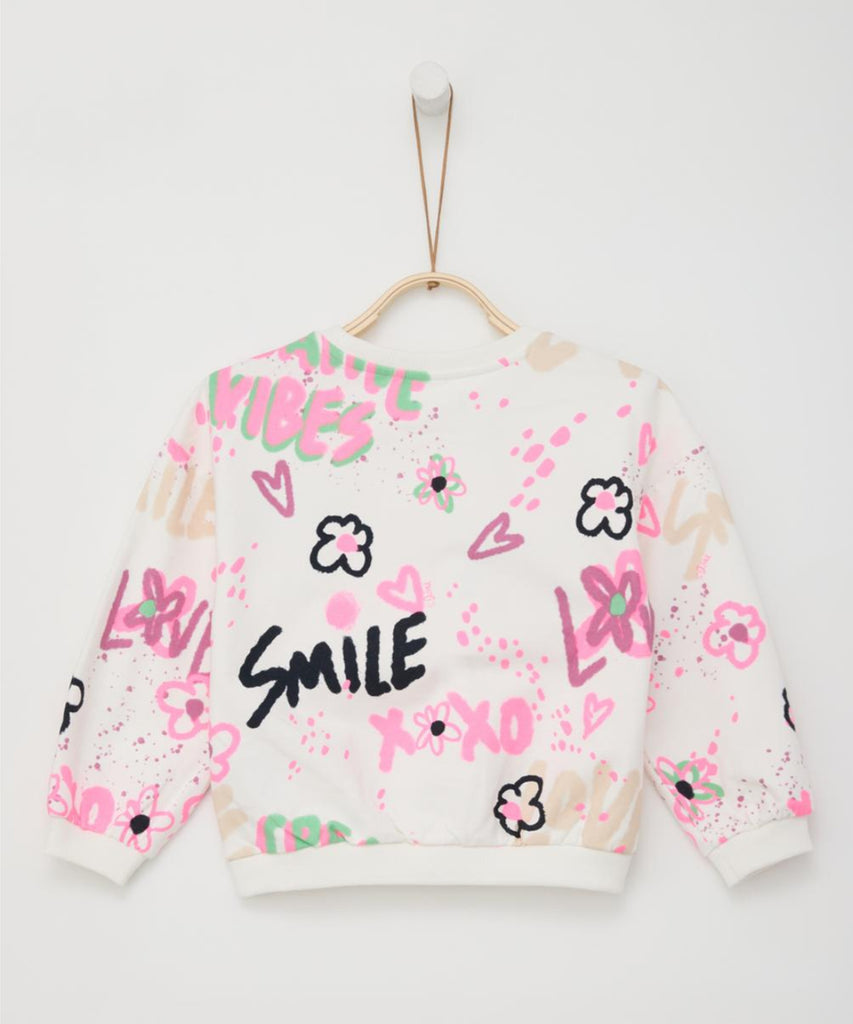 Details:  This girls Sweatshirt features a bold all over graffiti print, giving it a unique and edgy look. The round neckline, ribbed arm cuffs and waistband ensure a comfortable and secure fit. Perfect for any fashion-forward individual looking to make a statement.  Color: White  Composition: 090%CO 010%PES  