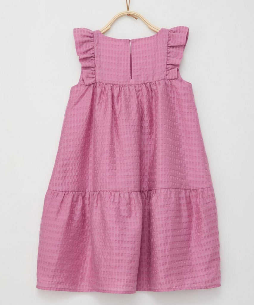 Details:  This girls' a-line dress in dark rose features whimsical frills and a versatile button-back closure. Its playful design is perfect for any occasion, while providing a secure and comfortable fit. Elevate her wardrobe with this charming and functional piece.  Color: Dark rose  Composition:  073%CLY 027%PA 