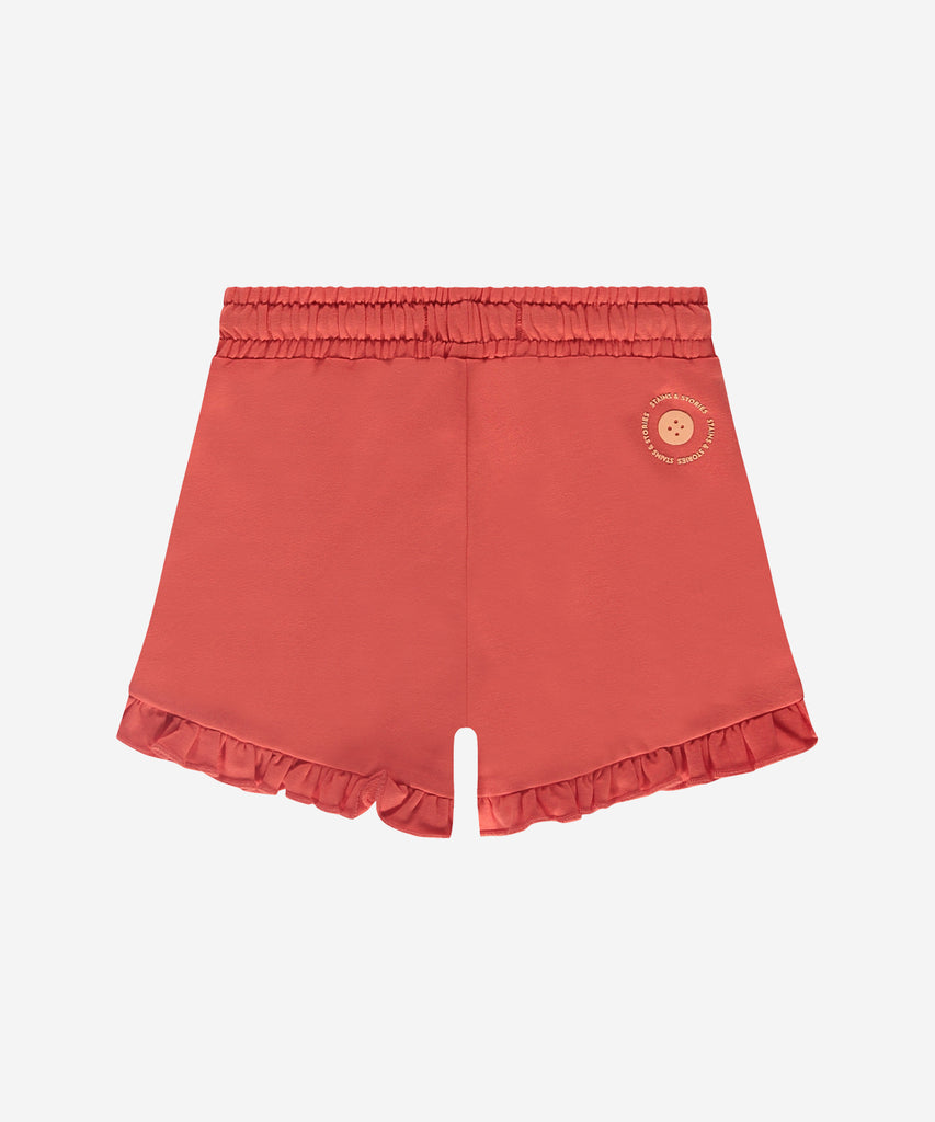 Details: Expertly crafted with a comfortable elastic waistband, these Soft Shorts Ruffles Grapefruit provide a stylish and comfortable fit. The delicate ruffles add a feminine touch to these soft shorts, making them perfect for lounging or wearing out and about.  Complete with practical pockets, these shorts are a must-have for any wardrobe.  Color: Grapefruit  Composition: 95% BCI cotton/ 5% elasthane  
