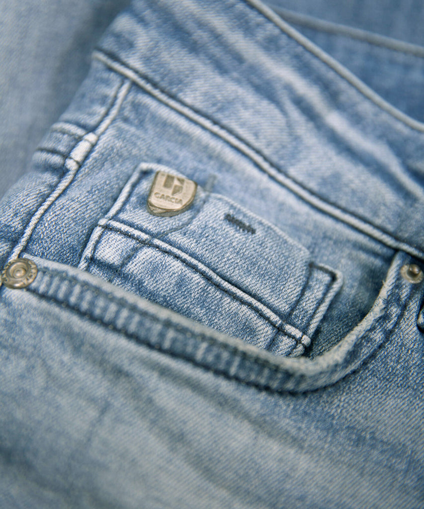 GARCIA Basic Junior Boys Collection  The Xandro 320 is a jeans with a superslim fit that fits tightly over the entire legs. The jeans has 5 pockets and closes with a zipper and button closure. The waistband can be easily adjusted by means of the elastic bands on the inside.  Colour: medium Blue used 