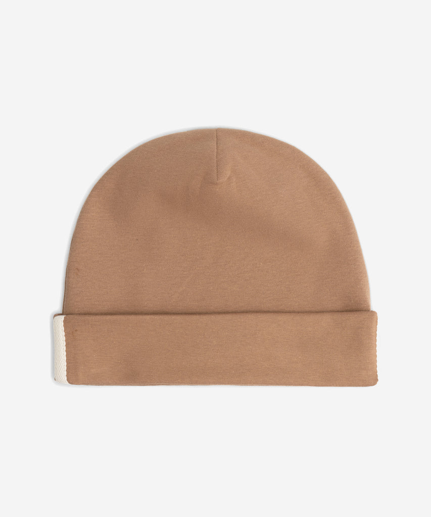 Details: Fitting comfortably over the head, this beanie offers lightweight protection from the cold. Made from the softest organic cotton rib, it has a folded brim and a herringbone detail on the sides.  Color: Biscuit  Composition: 96% Organic Cotton Jersey, 4% Elastane Rib  Made in Portugal