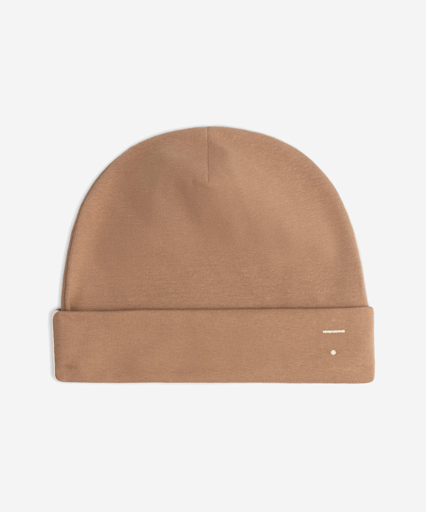 Details: Fitting comfortably over the head, this beanie offers lightweight protection from the cold. Made from the softest organic cotton rib, it has a folded brim and a herringbone detail on the sides.  Color: Biscuit  Composition: 96% Organic Cotton Jersey, 4% Elastane Rib  Made in Portugal