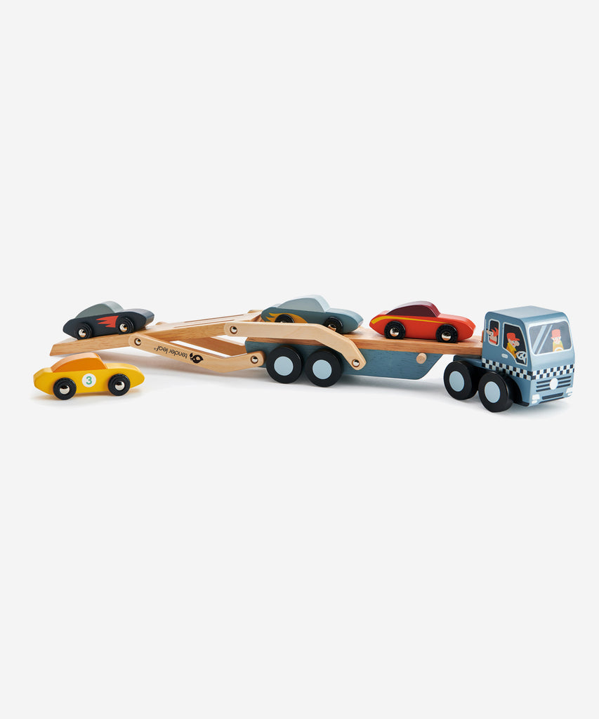 Tender Leaf®  A solid wood transporter with detachable carrier, 4 stylish super cars with metal wheels and a lift down boarding ramp. Check out the little dog in the front cabin!    Includes: 4 stylish cars with metal wheels, transporter truck with detachable carrier.  Age: 3 Years and older  Size: 51 x 8 x 13cm