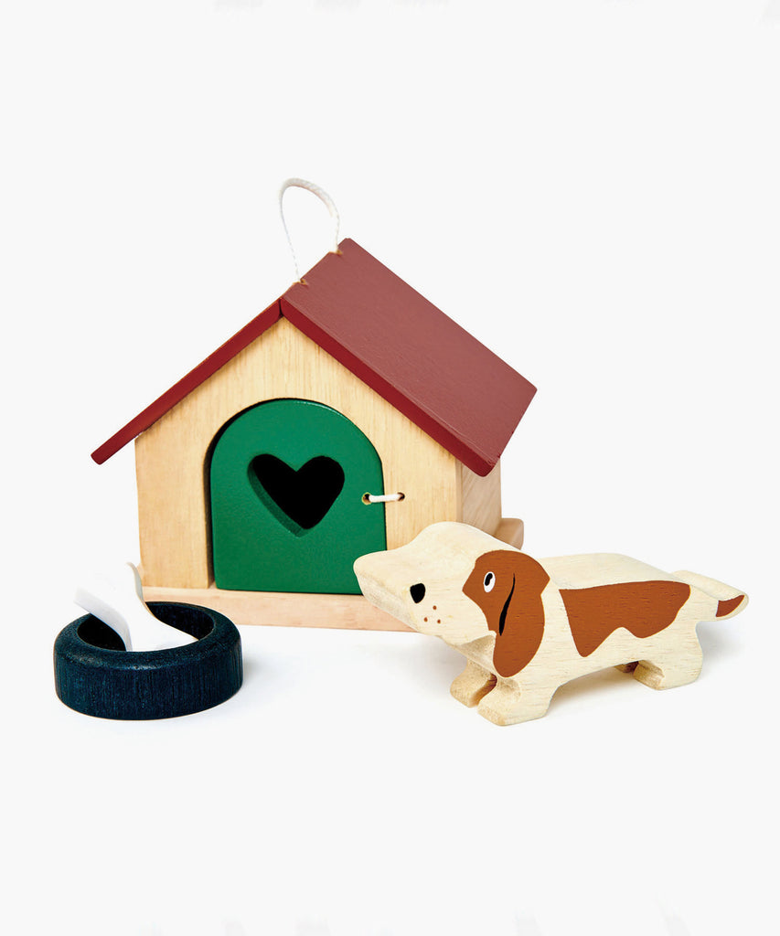 Tender Leaf®  A charming basset hound dog with a bowl and a bone. Pretty kennel with opening door and carry handle. Suitable for all the wooden dolls houses, as scaled to 1:12.   Includes: 19 wooden animals, 1 tree.  Age: 3 Years and older    Size: 7.7 x 12 x 6.5cm  Composition: wood 