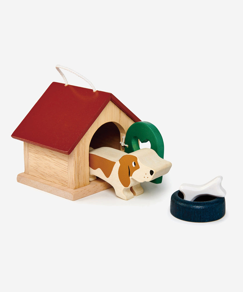 Tender Leaf®  A charming basset hound dog with a bowl and a bone. Pretty kennel with opening door and carry handle. Suitable for all the wooden dolls houses, as scaled to 1:12.   Includes: 19 wooden animals, 1 tree.  Age: 3 Years and older    Size: 7.7 x 12 x 6.5cm  Composition: wood 