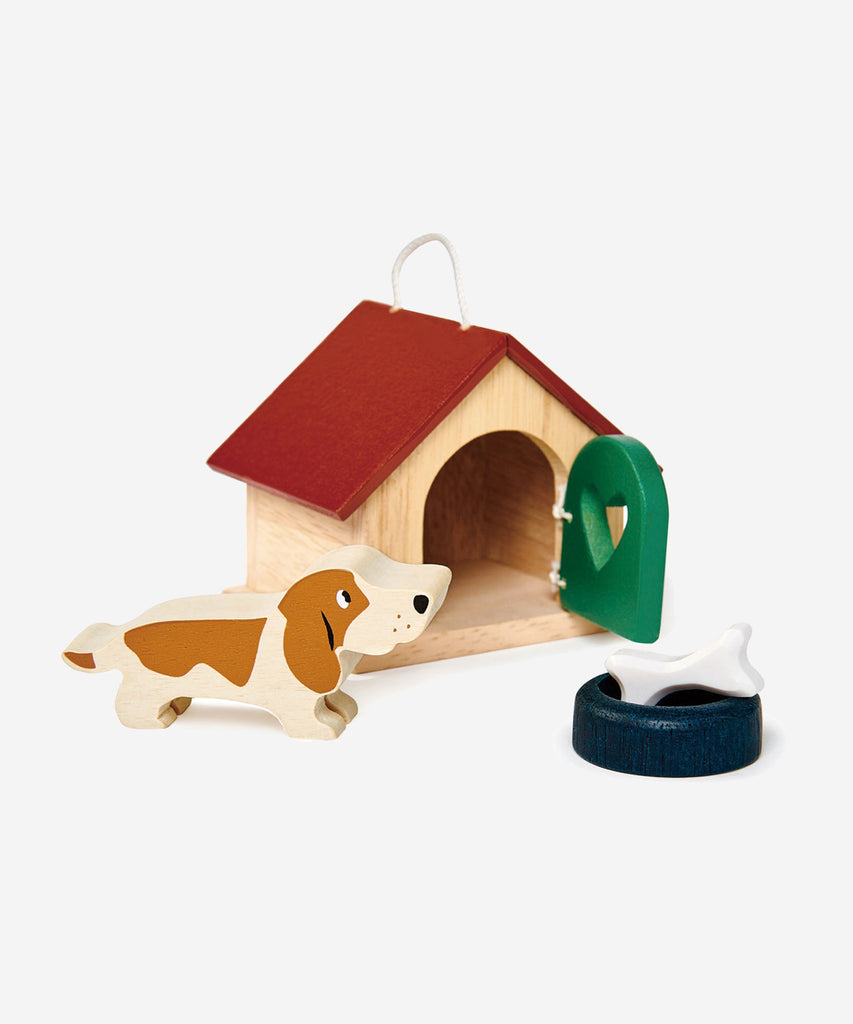 Tender Leaf®  A charming basset hound dog with a bowl and a bone. Pretty kennel with opening door and carry handle. Suitable for all the wooden dolls houses, as scaled to 1:12.   Includes: 19 wooden animals, 1 tree.  Age: 3 Years and older    Size: 7.7 x 12 x 6.5cm  Composition: wood 