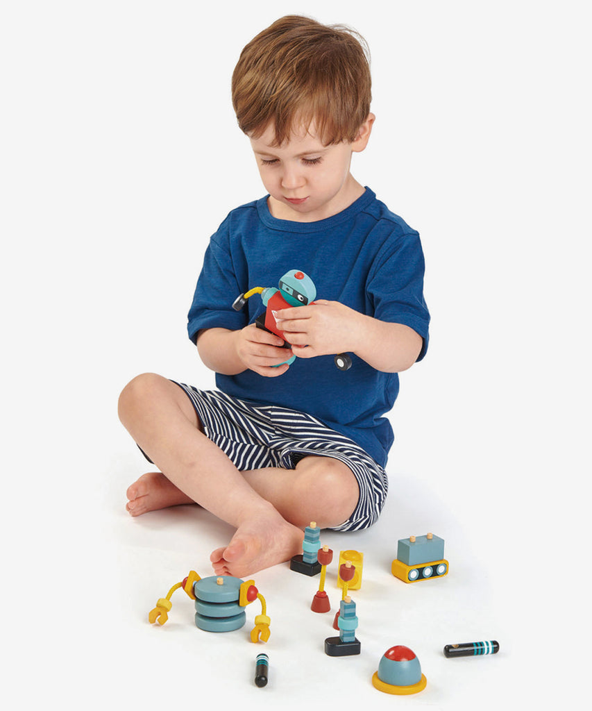 Tender Leaf®  3 brightly colored and retro style robots made from solid rubber wood that all come apart so that they can be reconstructed in a variety of ways for creative play.   Age: 3 Years and older  Size: Box 12.5 x 32 x 13cm Composition: sustainable and/or recycled wood 